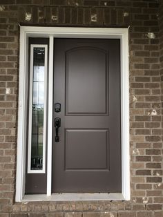 the front door is painted gray and has a glass paneled window with white trim