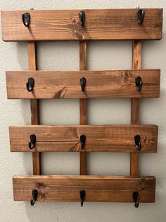 a wall mounted coat rack made out of wooden planks with black knobs on it