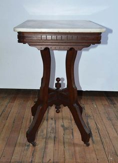 an old wooden table sitting on top of a hard wood floor