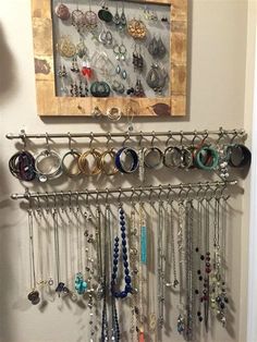 a wall mounted jewelry rack with many different types of earrings hanging from it's sides