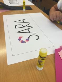 a child is doing crafts with crayons and glue on the table next to it