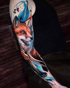 a person with a tattoo on their arm that has a fox and flowers on it