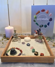 a wooden tray with rocks and candles on it next to a sign that says crystals