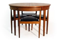 three wooden tables with black leather seats on each side and an oval shaped table in the middle