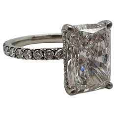 an engagement ring with a princess cut diamond and pave diamonds on the band, set in