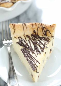 a slice of cheesecake with chocolate drizzled on it and a fork