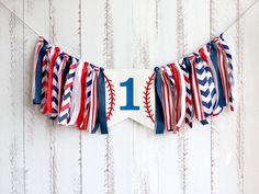 a baseball themed banner with the number one on it and red, white, and blue streamers