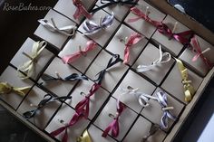 several pairs of scissors are tied together in different colors and sizes, sitting on top of a cardboard box