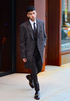 a man in a suit and tie walking down the street