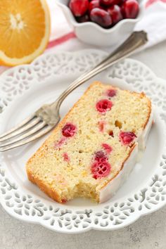 a piece of cake on a white plate with fork and bowl of fruit in the background