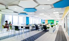 an empty office with blue, yellow and white decor on the ceiling is pictured in this image