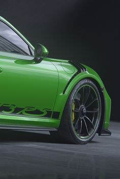 a green sports car parked in front of a black background