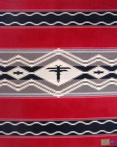 a red and black blanket with a cross on it