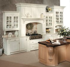 a large kitchen with white cabinets and marble counter tops