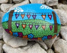 a painted rock sitting on top of some rocks