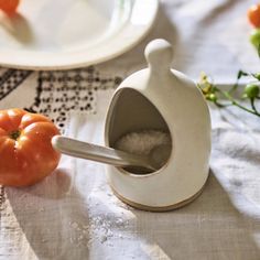 a salt and pepper shaker sitting on top of a table next to some tomatoes