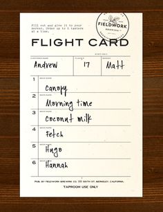 a flight card with writing on it sitting on top of a wooden table next to a pen