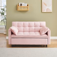 a pink couch sitting on top of a hard wood floor