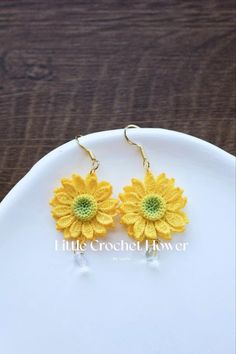 yellow flower earrings on a white plate