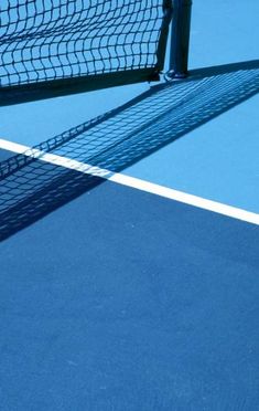 the shadow of a tennis player on the court