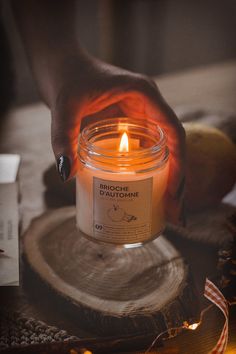 a person holding a lit candle on top of a table