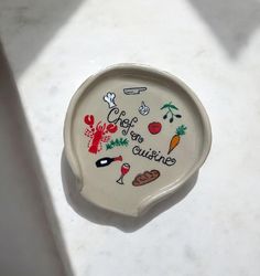 a white plate with the words chef on it is sitting on a counter next to a knife and fork