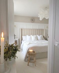 a bedroom with a bed and candles in the corner, next to a planter filled with flowers