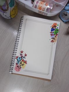 an open notebook sitting on top of a wooden table next to toys and other items