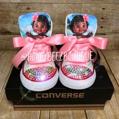 a pair of shoes with pink bows on the side and an image of princess pooh