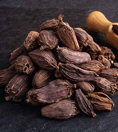 cloves and a wooden spoon on a black surface