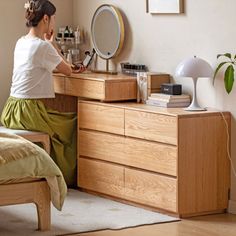 a woman sitting at a dresser in front of a mirror