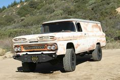 an old rusted truck is parked in the dirt