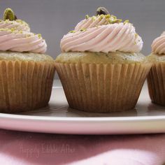 three cupcakes with frosting and sprinkles are on a plate