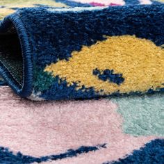 a close up of a rug with blue, yellow and pink colors