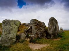 several large rocks sitting in the grass under a cloudy sky