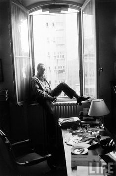 a man sitting at a desk in front of a window