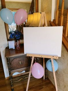 an easel with balloons on it in front of a mirror