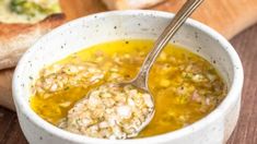 a white bowl filled with soup next to bread