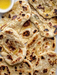 several flat breads on a plate with dipping sauce