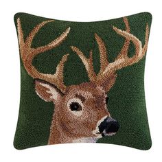 a pillow with a deer's head on the front and green background, which is made out of sequins