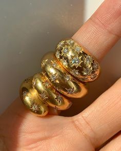 a woman's hand holding a gold ring with diamonds on it