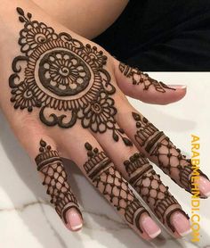 a woman's hand with henna tattoos on it