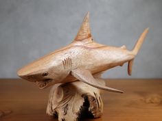 a wooden sculpture of a shark on top of a piece of wood that has been carved into it