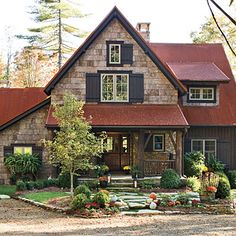 a house in the woods with lots of trees and shrubs on the front lawn area