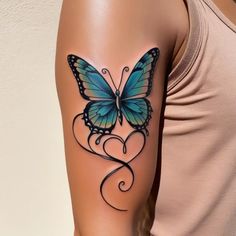 a woman's arm with a blue butterfly tattoo on the left side of her arm