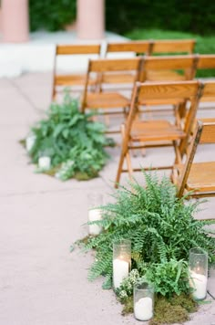 an outdoor ceremony with wooden chairs and candles