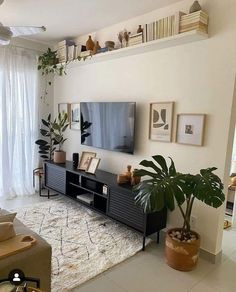 a living room filled with furniture and a flat screen tv on top of a wooden stand