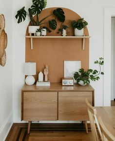 a wooden table topped with potted plants next to a wall mounted shelf