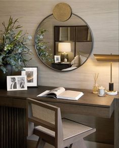 a desk with a mirror, lamp and pictures on it