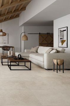 a living room filled with white furniture and wooden ceiling beams in an open concept space